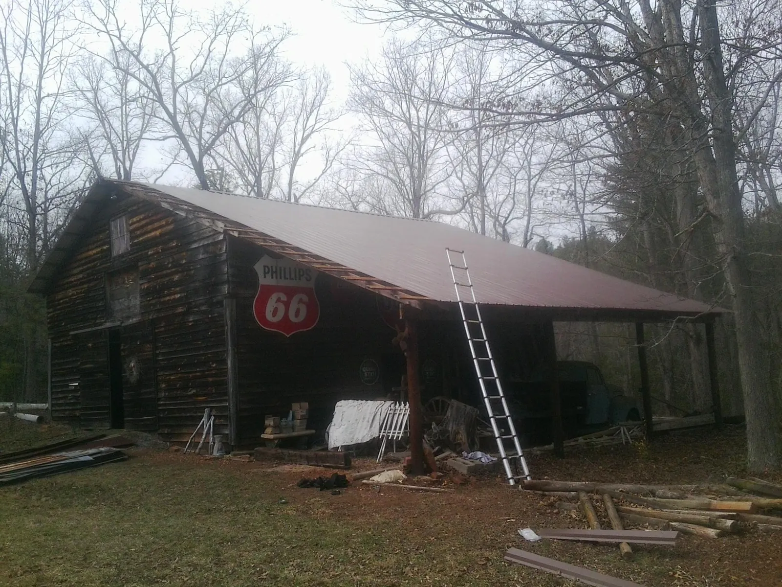New metal roof on an open sided timber barn with a vintage sign in Chualar