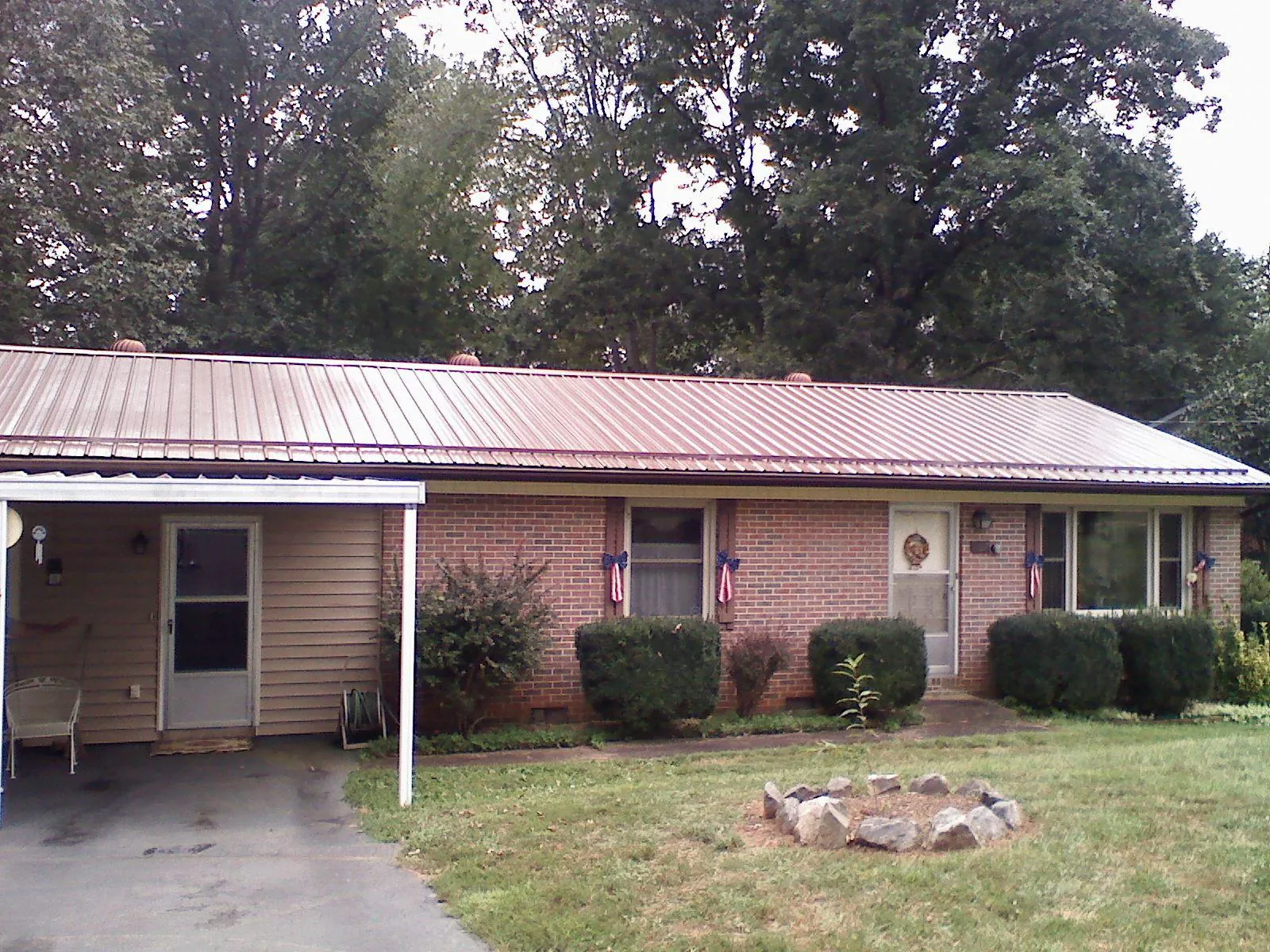 Bronze metal roof and carport on a brick ranch home — Roof Repair work by our crew in Chualar